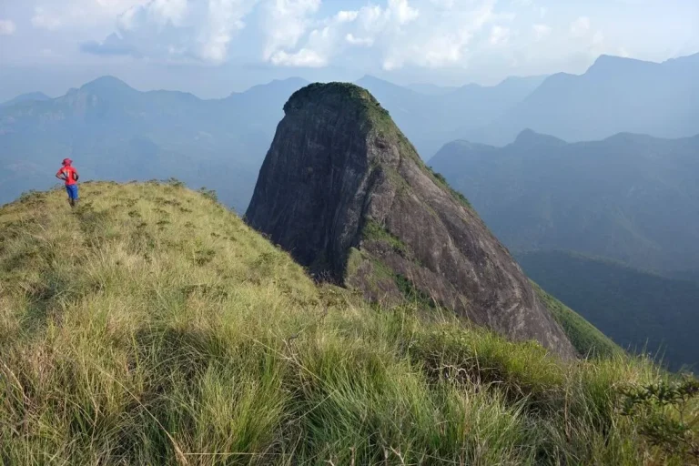 A hiker stands on the edge of Lakgala peak in the Knuckles Range, Sri Lanka