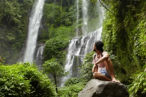Adventurous traveler gazing at a majestic waterfall in Sri Lanka.
